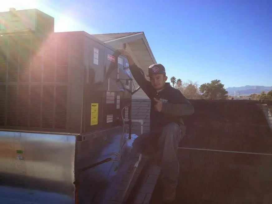 HVAC technician performing AC Tune-Up on a rooftop unit in Wilsonville